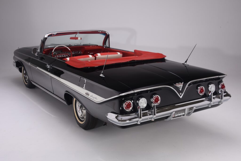 Classic black convertible car with red interior and vintage design.