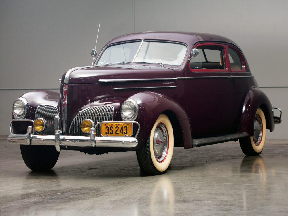 Classic maroon vintage car with whitewall tires on display.