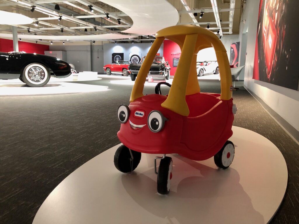 A red and yellow toy car with cartoon eyes on display.