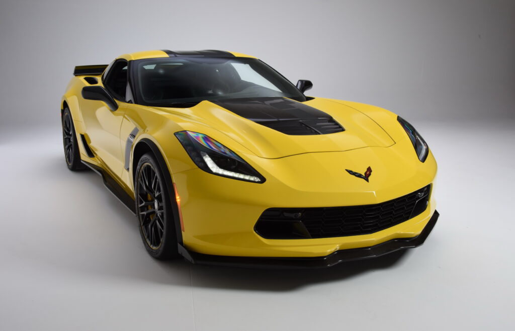 Yellow Chevrolet Corvette sports car with sleek design on white background.