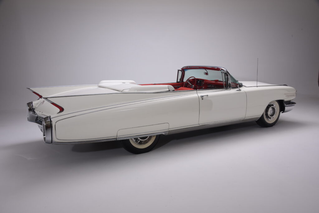 Classic white convertible car with red interior and sleek tailfins.