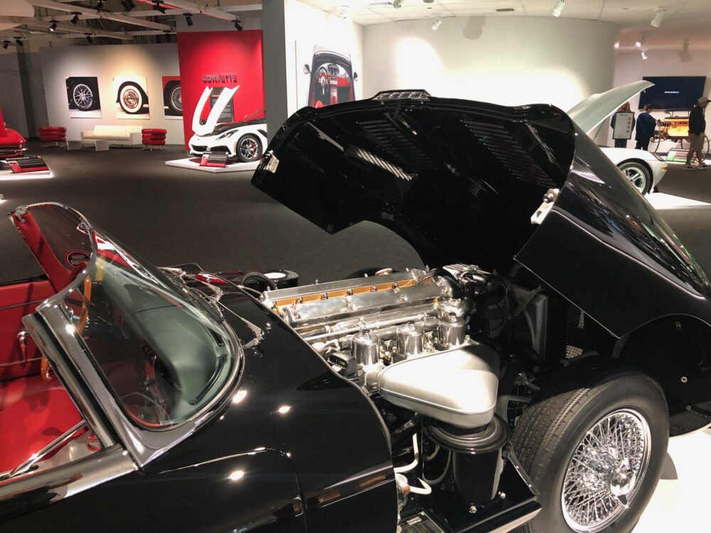 Classic black car with hood open showing polished engine.