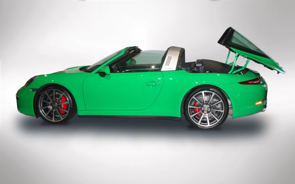 Bright green Porsche convertible with sleek design and red brake calipers.