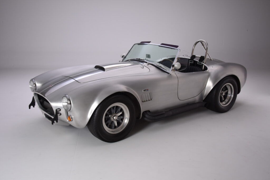 Silver classic convertible sports car with black racing stripes.