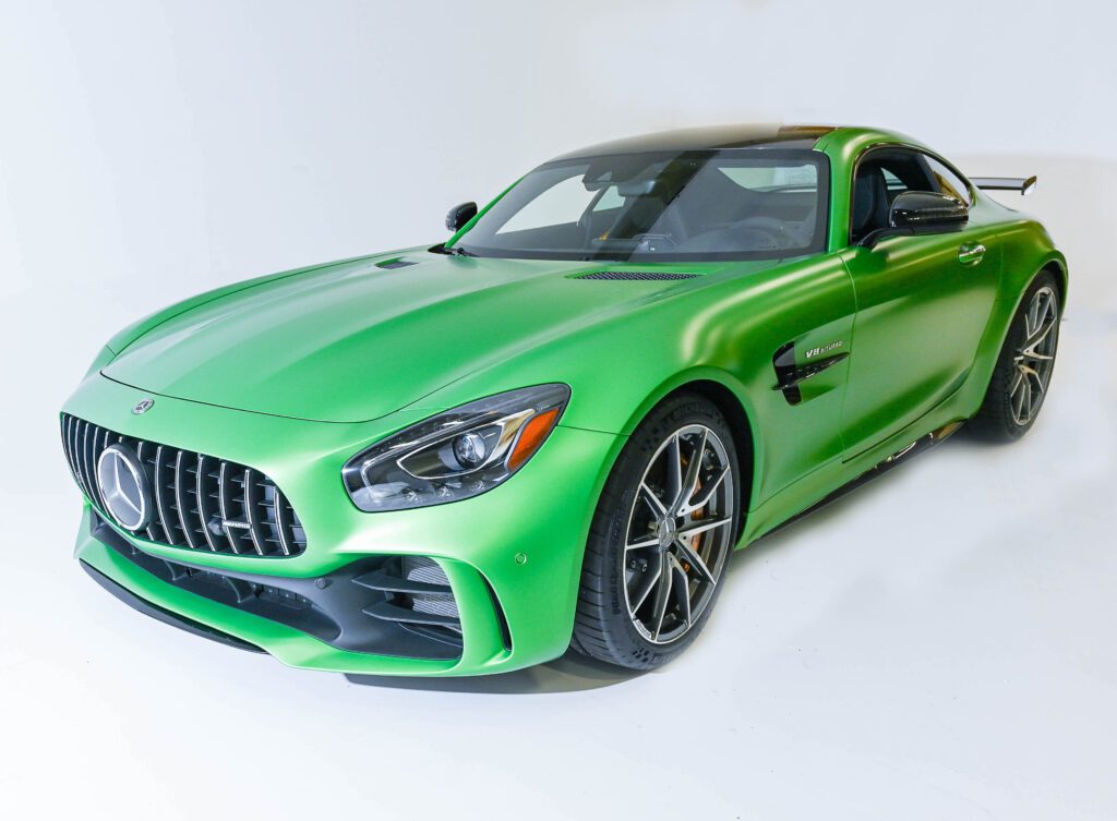 Sleek green sports car with aerodynamic design and black rims.