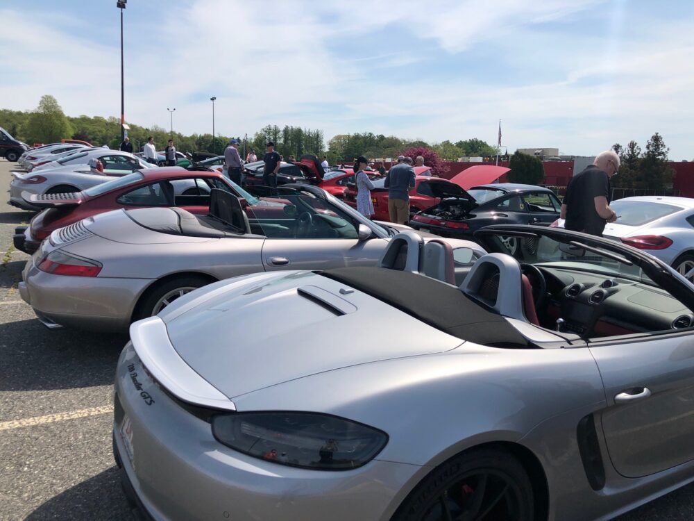 A row of sports cars parked outdoors at a car meet.