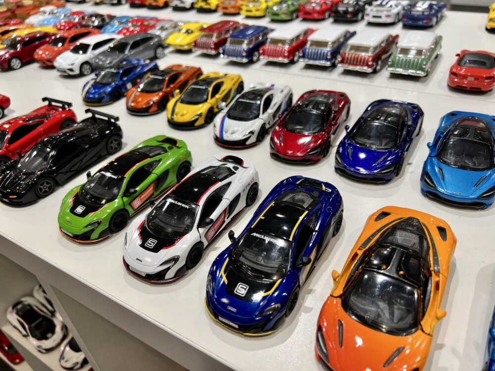 A collection of colorful toy sports cars neatly displayed on a white surface.