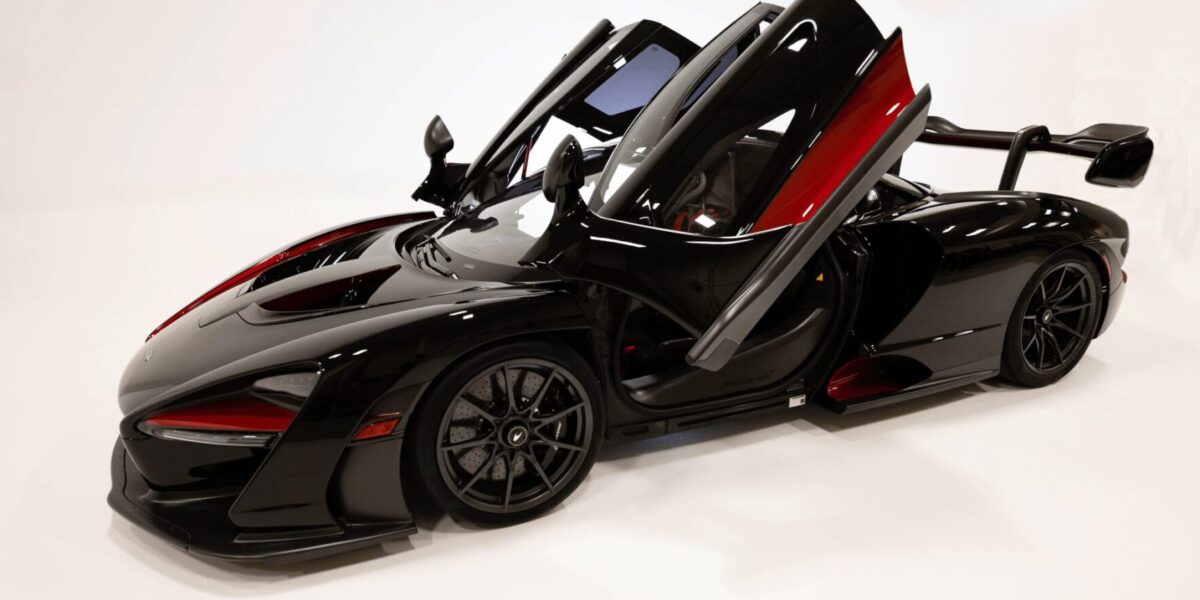 A sleek black sports car with butterfly doors open. A sleek black sports car with butterfly doors open.