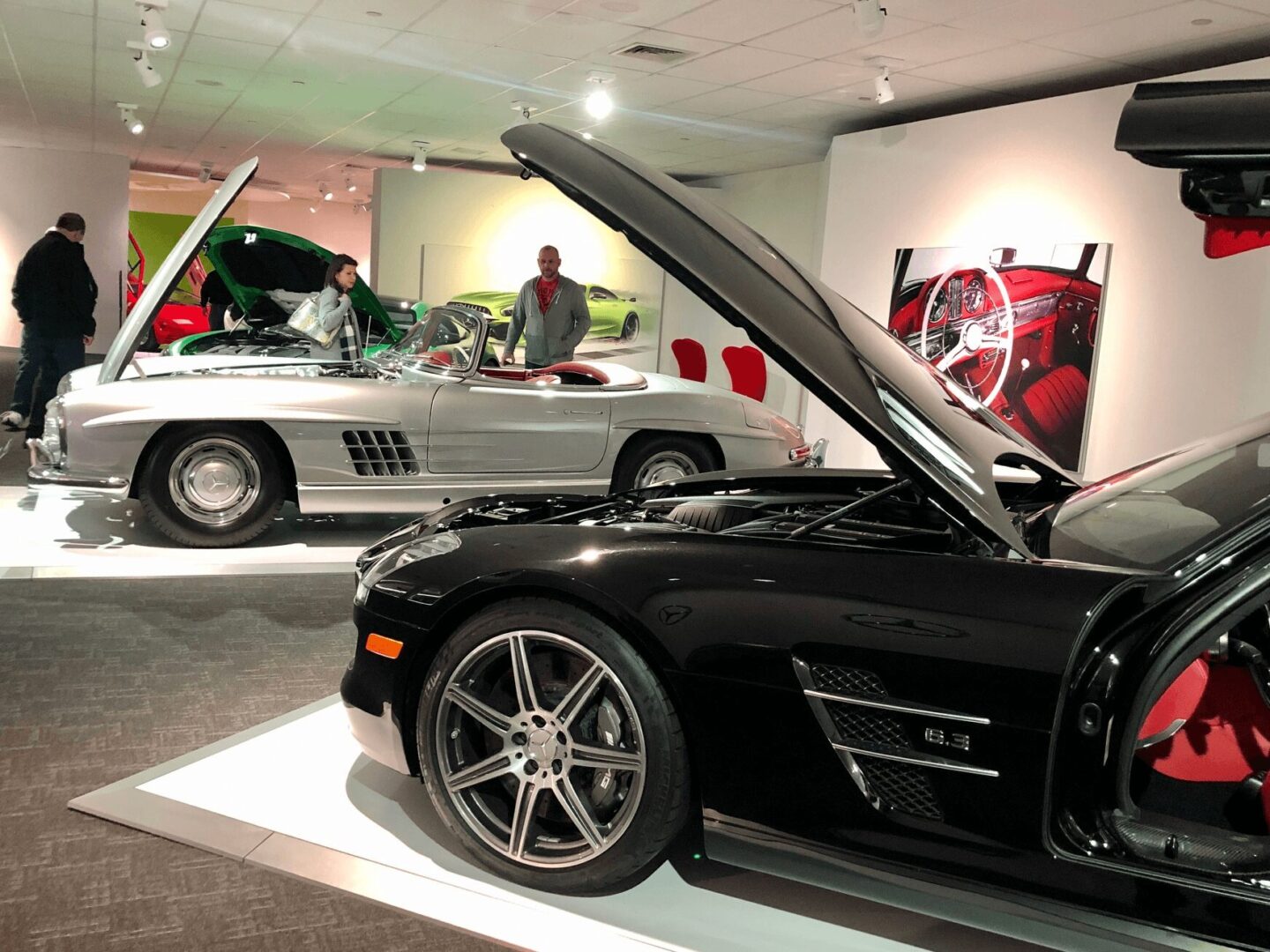 Luxury sports cars displayed in a sleek showroom with modern lighting.