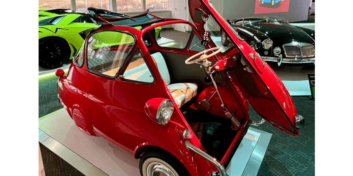 Red vintage microcar with butterfly doors on display indoors. Red vintage microcar with butterfly doors on display indoors.