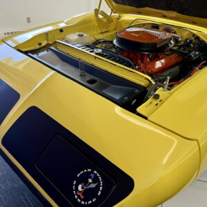 Close-up of a yellow vintage car engine with a red air filter.